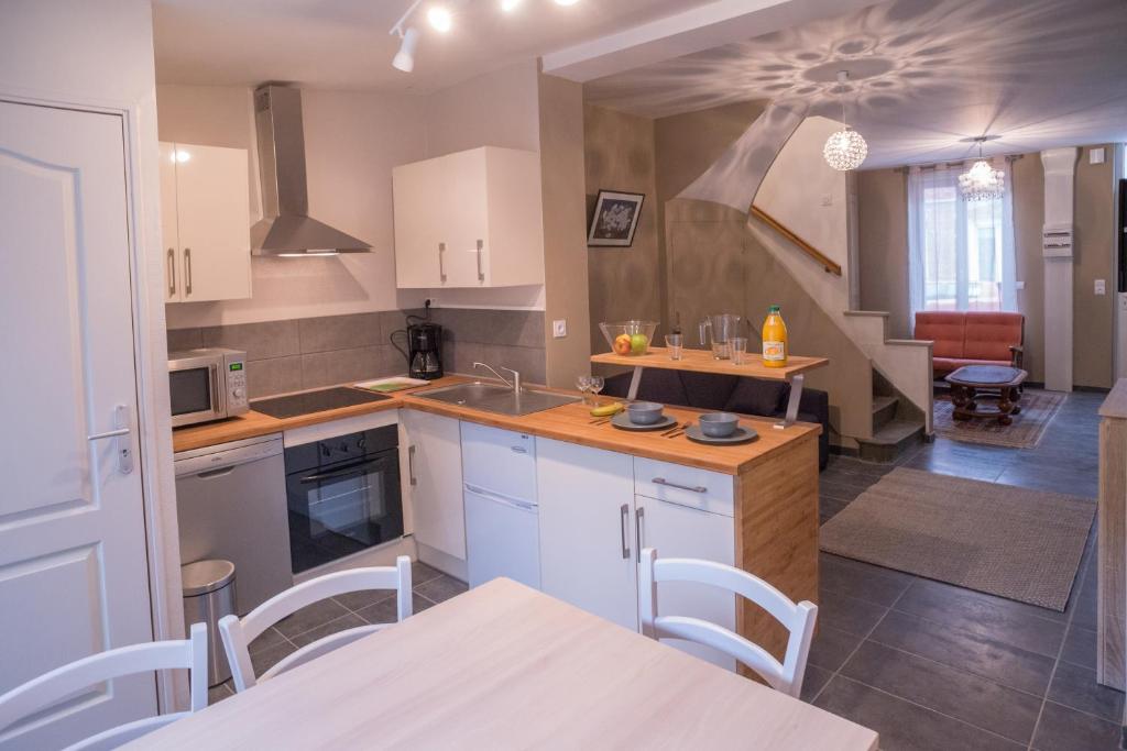 a kitchen with white cabinets and a table and chairs at Gite Amiens in Amiens