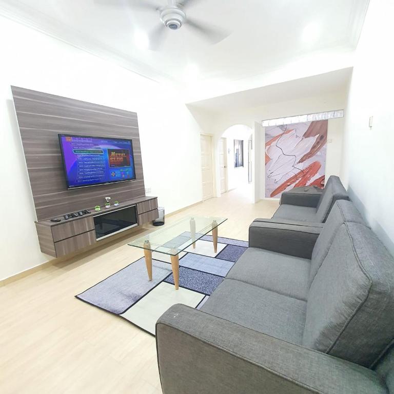 sala de estar con sofá y TV de pantalla plana en KuantanBukitSetongkolArea3R2B.HTAA/TOWN-5min only en Kuantan