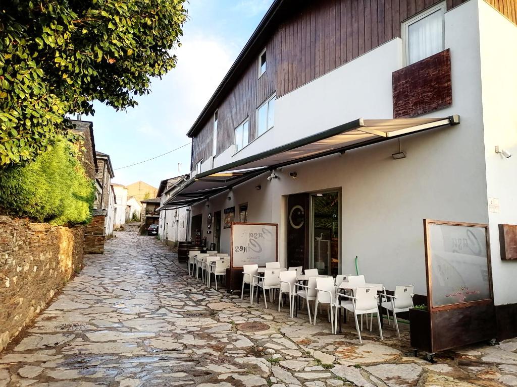 un callejón empedrado con mesas y sillas fuera de un edificio en CASA CINES, en Lugo