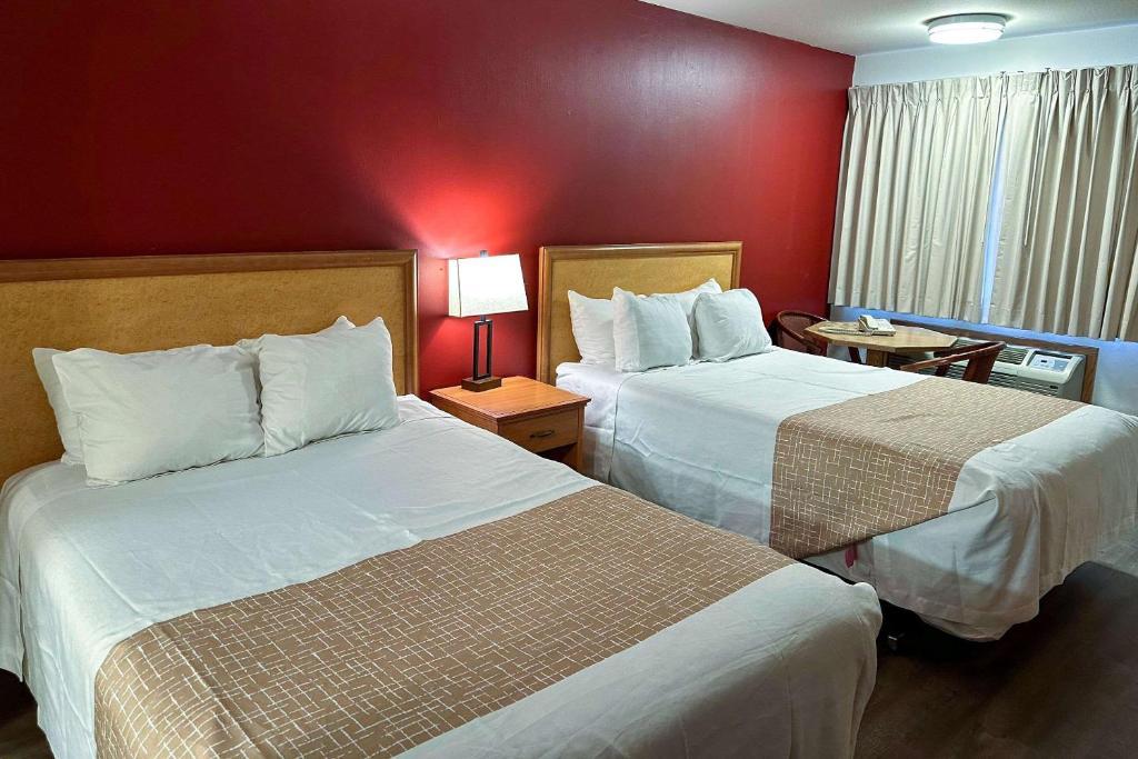 ein Hotelzimmer mit 2 Betten und einer roten Wand in der Unterkunft Econo Lodge Edmonds North Seattle in Edmonds