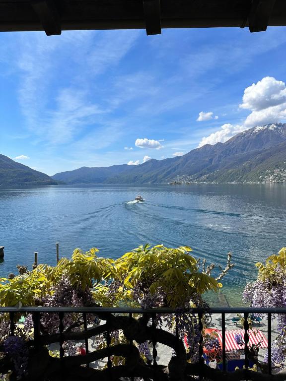 a boat on a lake with mountains in the background at Appartamento Ascona Vista Lago in Ascona
