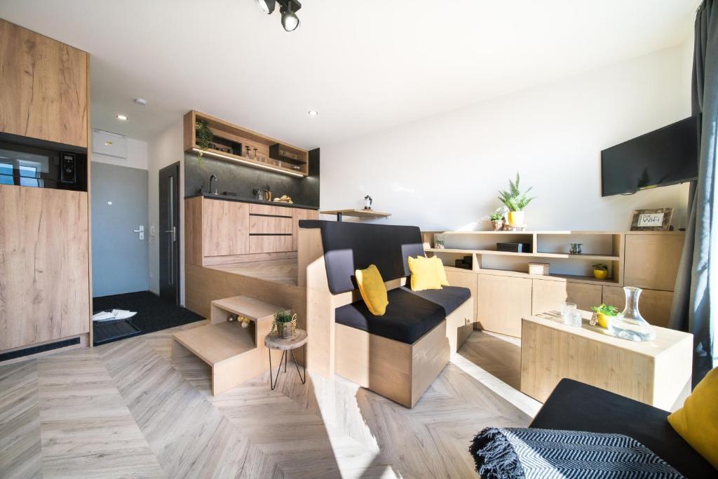 a living room with a couch and a kitchen at Internesto Brno Vlhka 9 in Brno