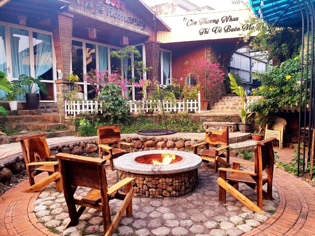 un patio avec des chaises et un foyer extérieur en face d'un bâtiment dans l'établissement Boss cà phê & Homestay Nguyên căn, à Chi Lăng