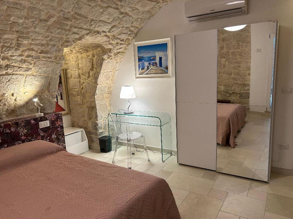 a bedroom with two beds and a mirror in a room at Suite Duomo Trani 6 in Trani
