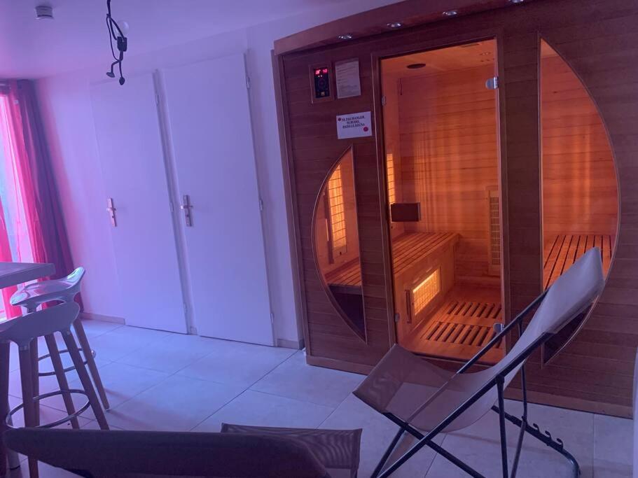 Cette chambre dispose d'une chaise et d'une armoire en bois. dans l'établissement Maison entière avec sauna privatif Sauna sur Sye, à Aouste-sur-Sye
