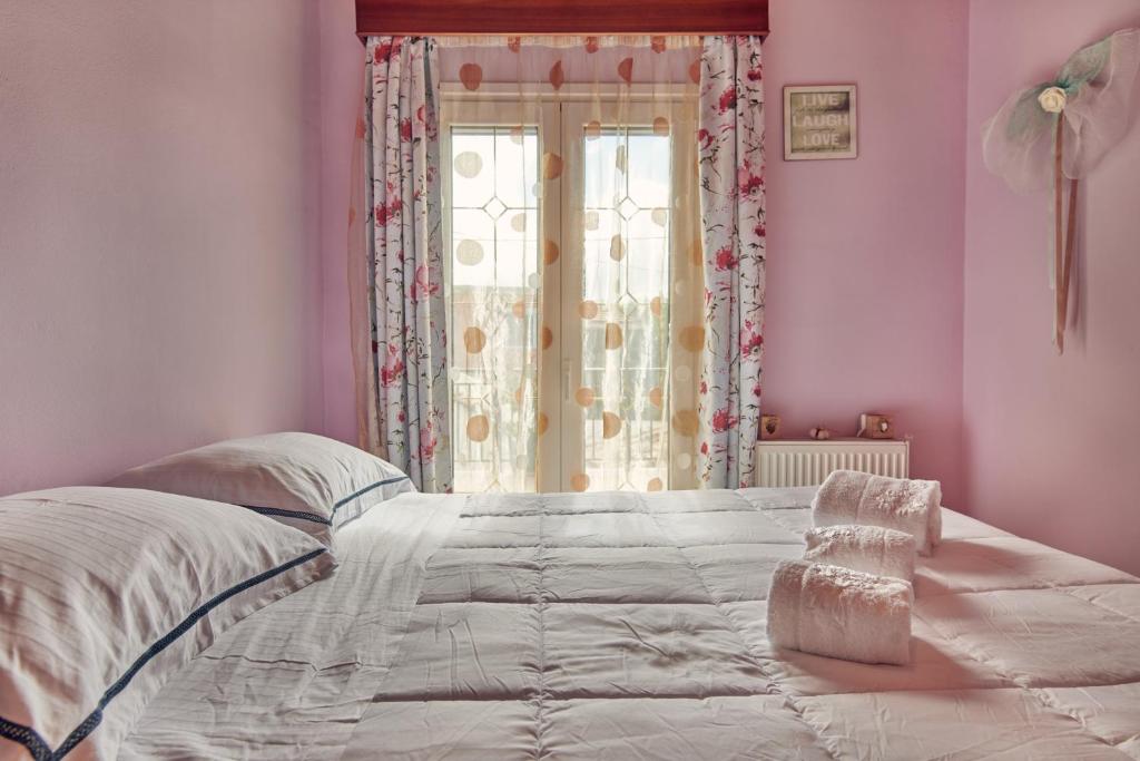 a bedroom with a large bed with a window at Villa Roxa Montuoso in Agios Leon
