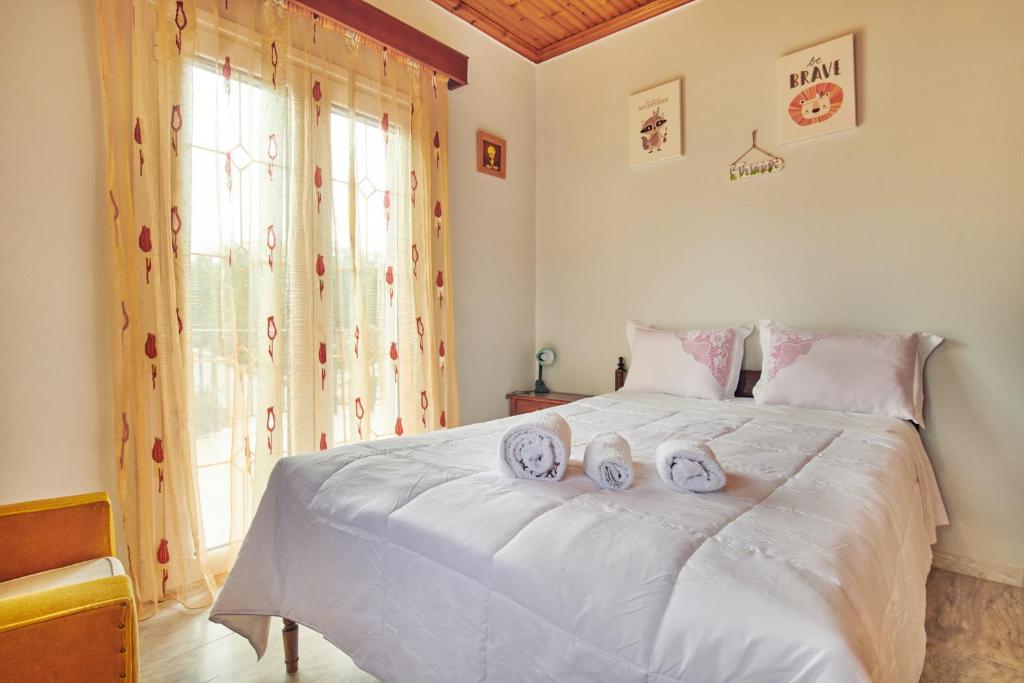 a bedroom with a white bed with two towels on it at Villa Roxa Montuoso in Agios Leon