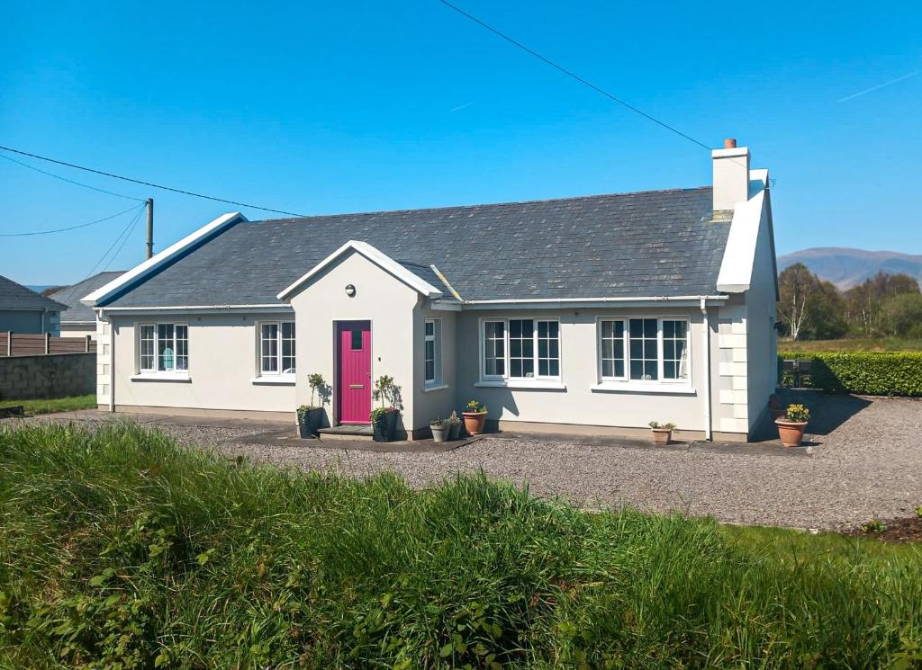 een wit huis met een rode deur bij Shannons Gate in Killorglin
