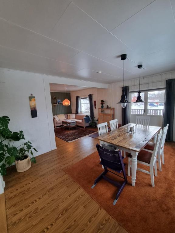 een eetkamer en een woonkamer met een tafel en stoelen bij Hus i naturskjønne omgivelser in Hopen