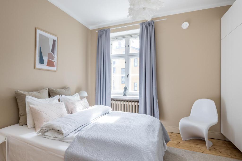 ein Schlafzimmer mit einem weißen Bett und einem Fenster in der Unterkunft Prestige City Home in Helsinki