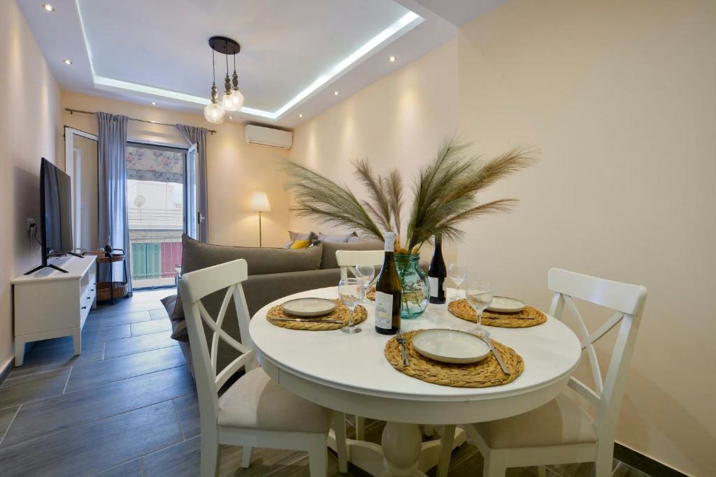 a dining room with a white table and chairs at Saroko House in Corfu