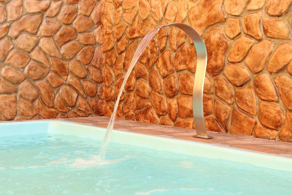 a water fountain in a swimming pool at Casa de Temporada RA Olímpia in Olímpia