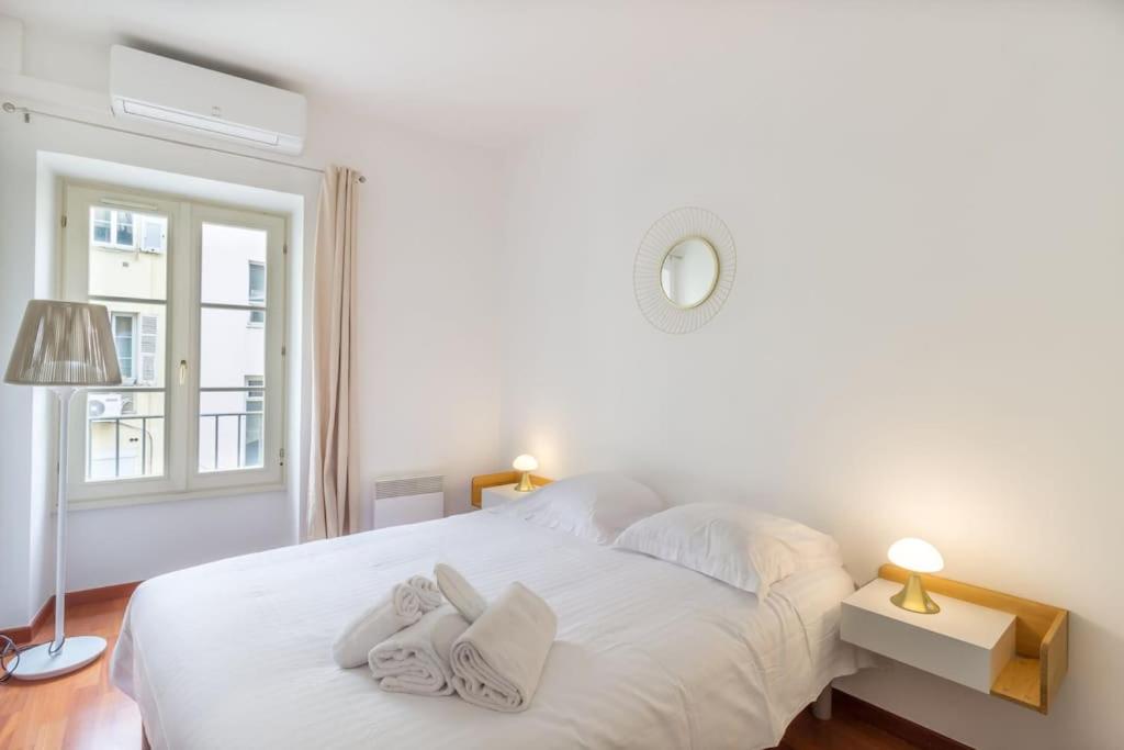 une chambre avec un lit blanc avec des serviettes dessus dans l'établissement L13 Central flat 5mins walk to beach AC/Balcon/WIFI, à Nice