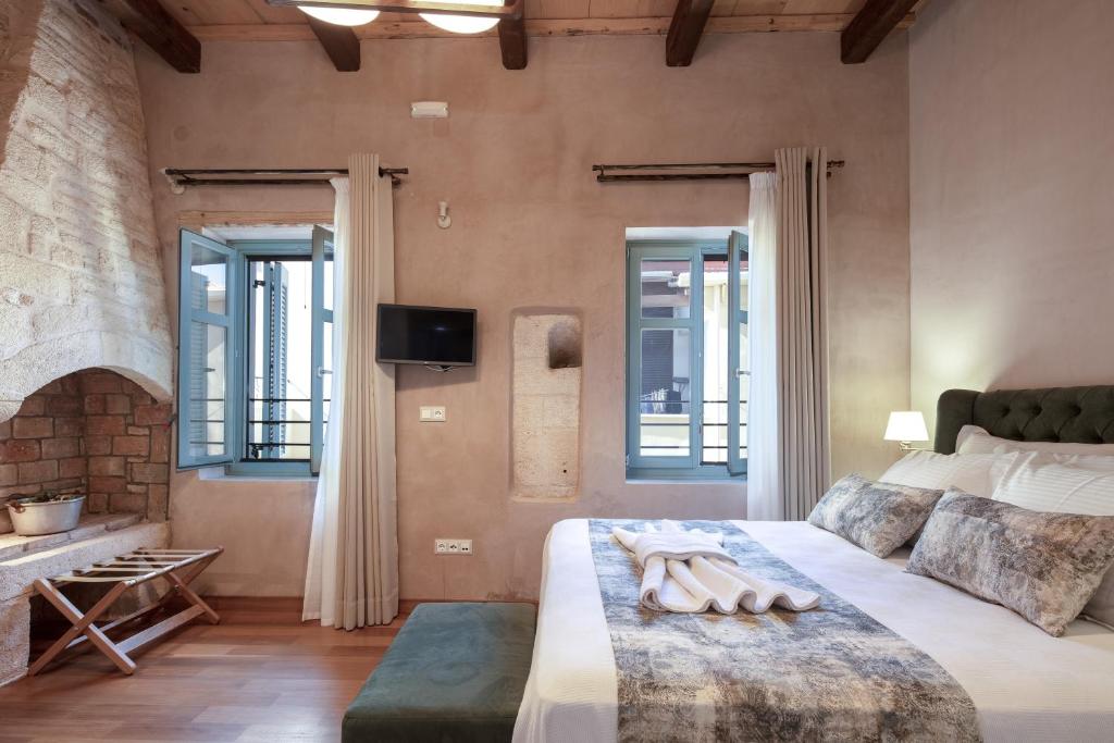 a bedroom with a bed and a fireplace at DOMUS CLODIA, sensing Rethymno's Old Town! in Rethymno Town