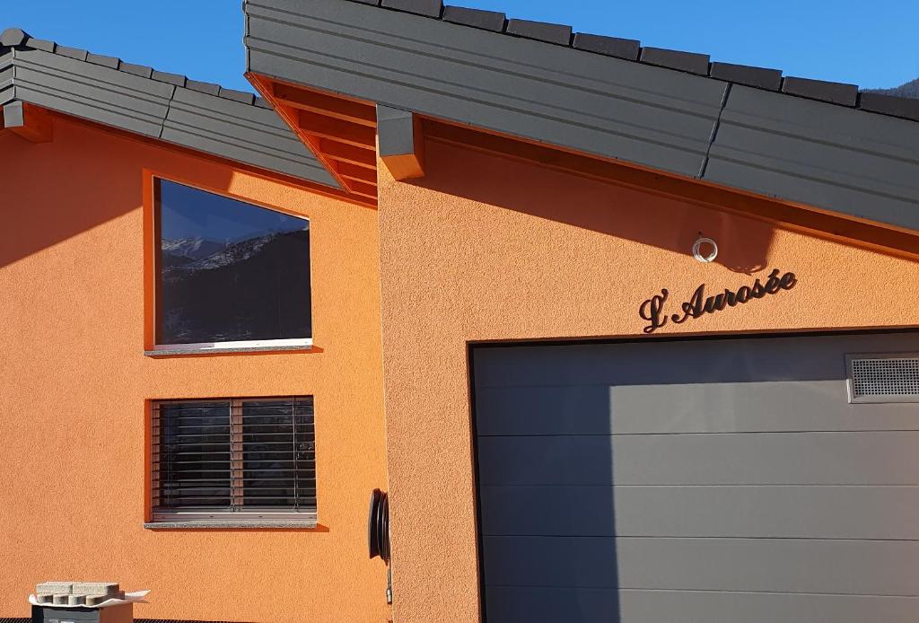 a building with a garage door and a window at L'Aurosée in Savièse