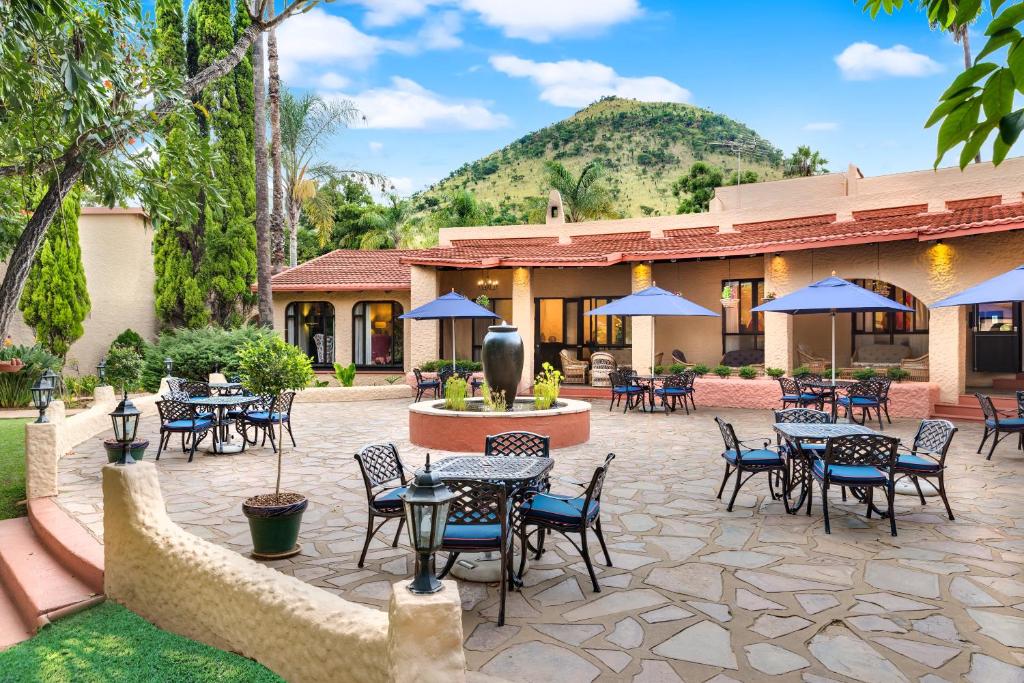 a patio with tables and chairs in front of a building at Malaga Hotel in Panorama