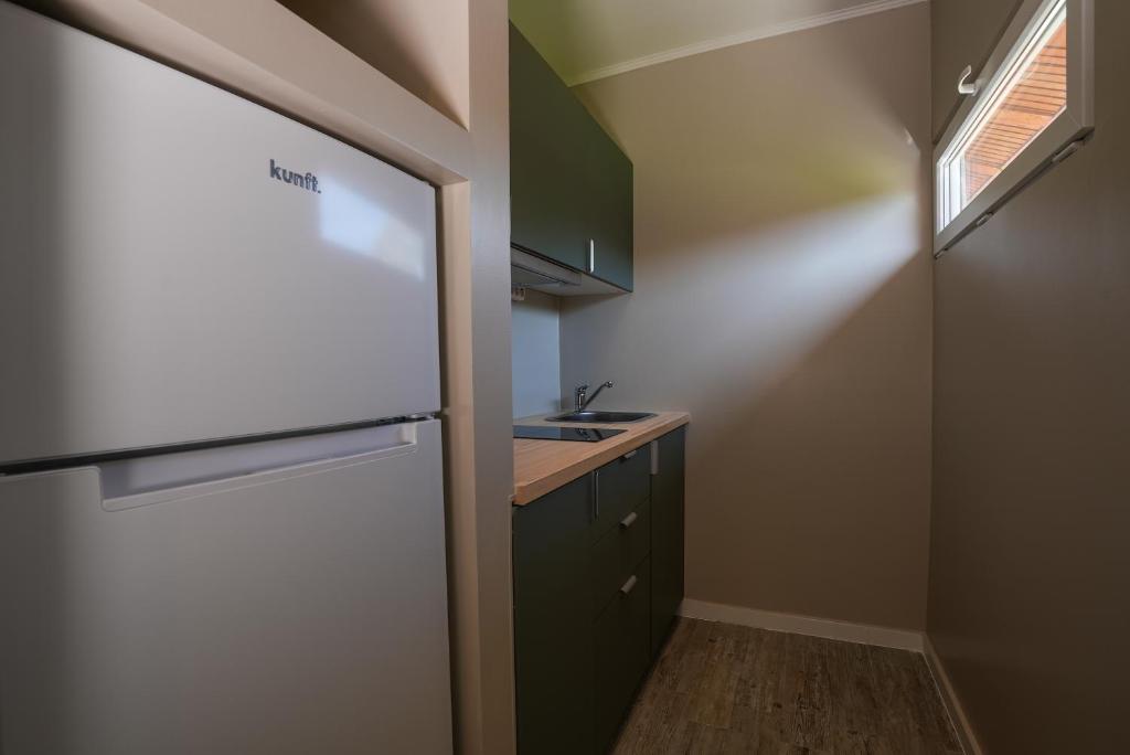 a small kitchen with a refrigerator and a sink at Quinta da Bicuda in Cascais