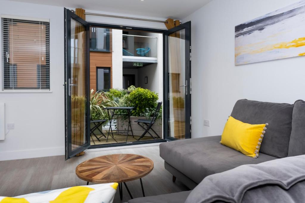 a living room with a couch and a table at 2 Middlecombe - Luxury Apartment at Byron Woolacombe, only 4 minute walk to Woolacombe Beach! in Woolacombe