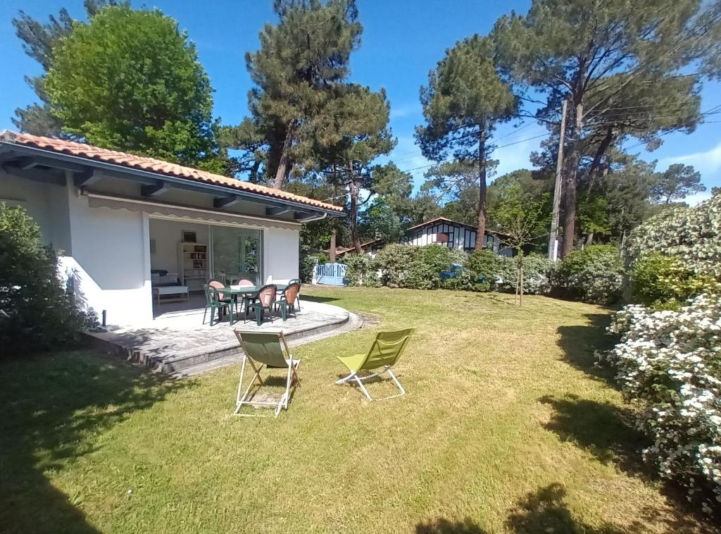 ラ・テスト・ド・ビュシュにあるPyla-sur-mer maison 2 chambres et jardin - à 400m des plagesの椅子とテーブル付きの庭園の景色を望めます。