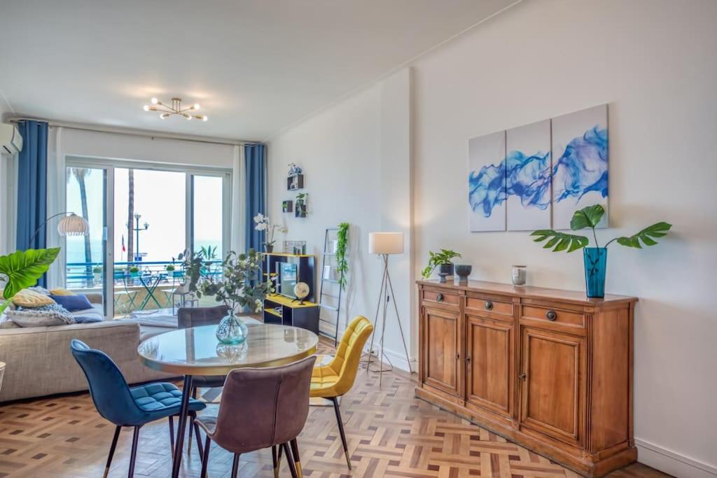 sala de estar con mesa, sillas y sofá en L14 2P Promenade Vue Mer climatisé, spacieux/ Balcon, en Niza