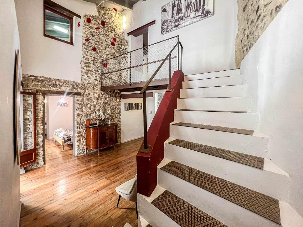 una escalera en una sala de estar con una pared de ladrillo en CAN FRUITÓS Alojamiento rural en Besalú, en Besalú
