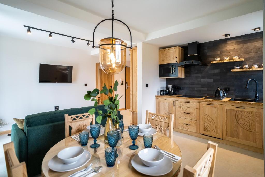 een keuken en eetkamer met een tafel en stoelen bij Apartament Niedźwiedź na Giewoncie by Apart Concept Podhale in Kościelisko