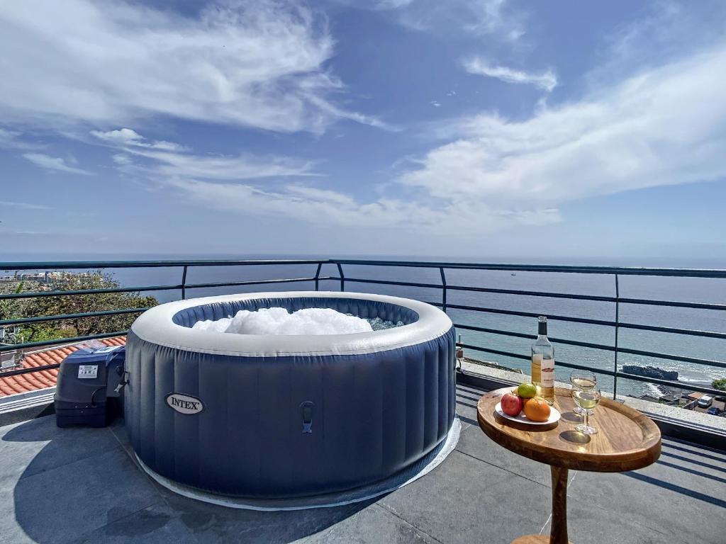 una vasca idromassaggio situata sopra un balcone con tavolo di Villa Formosa View by Atlantic Holiday a Funchal