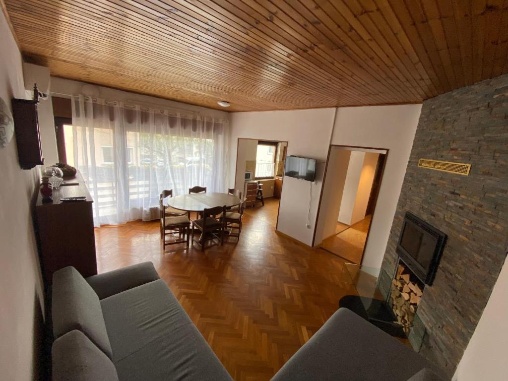 ein Wohnzimmer mit einem Tisch und einem Kamin in der Unterkunft Apartma Magnolija in Nova Gorica