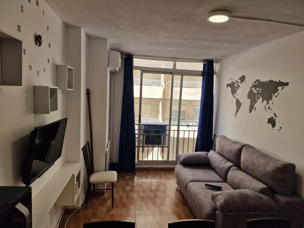 a living room with a couch and a tv at Aventura Playa y Sol Santa Pola in Santa Pola