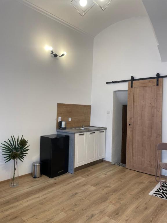 a room with a kitchen with a counter and a table at DMR Apartments in Košice