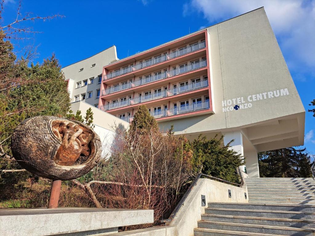 a hotel with a sculpture in front of a building at Hotel Centrum Brno in Brno