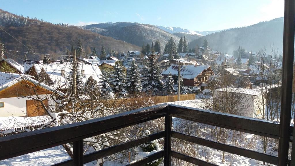 a view of a snow covered village from a balcony at Apartament Potecuta Ursului in Buşteni