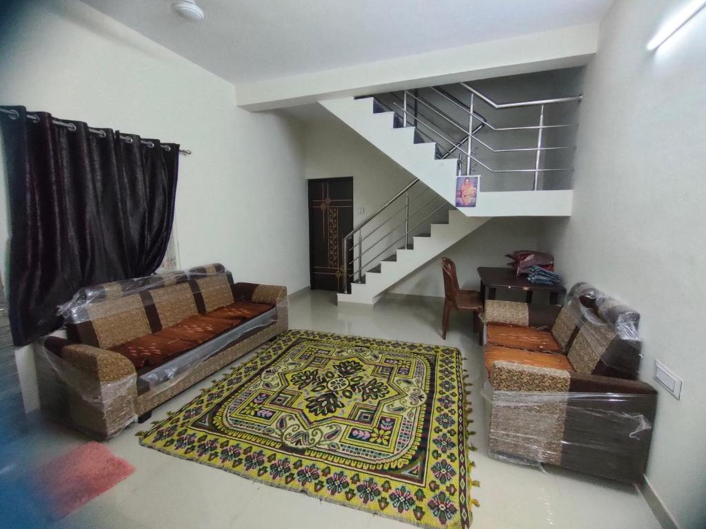 een woonkamer met een bank en een tapijt bij My Nest - Best Homestay for Peaceful Stay with Comfort in Bhuj