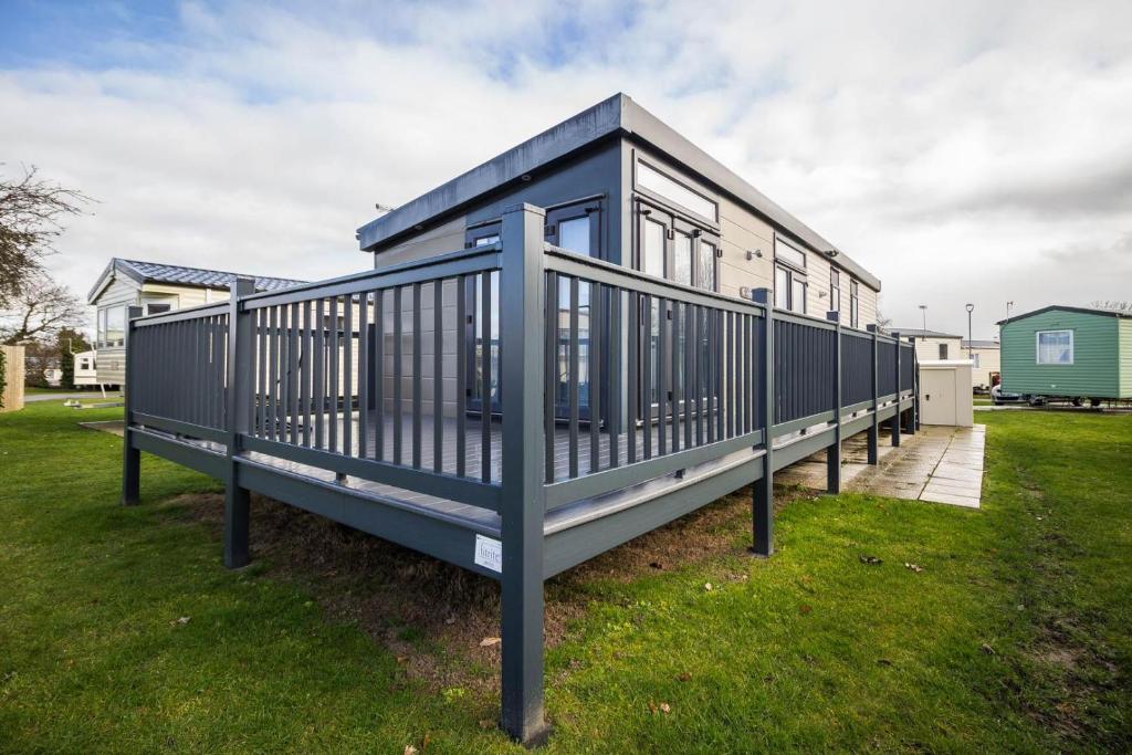 a blue tiny house in a yard at Modern 6 Berth Caravan With Decking At Cherry Tree Park In Norfolk Ref 70324c in Great Yarmouth