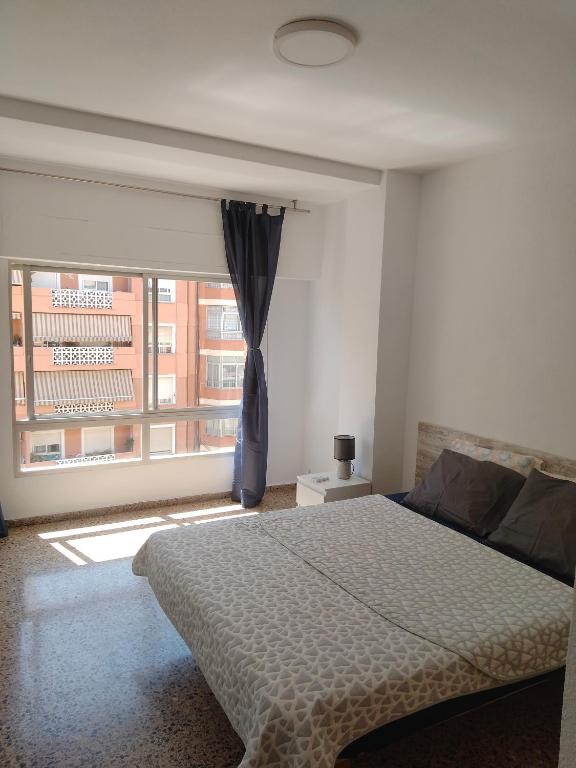 a bedroom with a bed and a large window at City Centre apartments in Denia