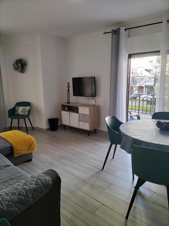 a living room with a table and a tv at T2 Vista Atlantica 3 minutos da praia de Quarteira in Quarteira