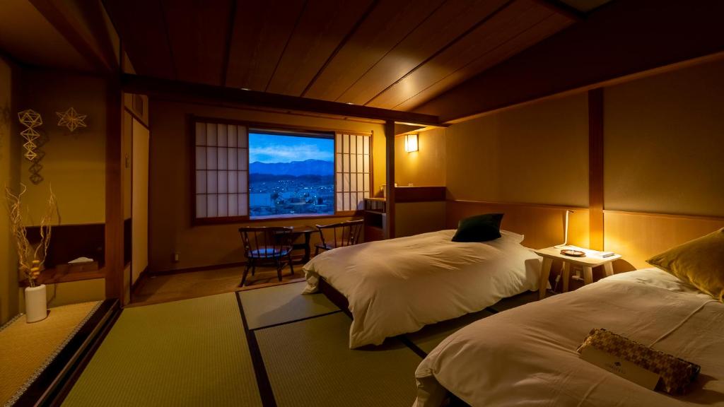 Postel nebo postele na pokoji v ubytování onsen hotel OMOTO