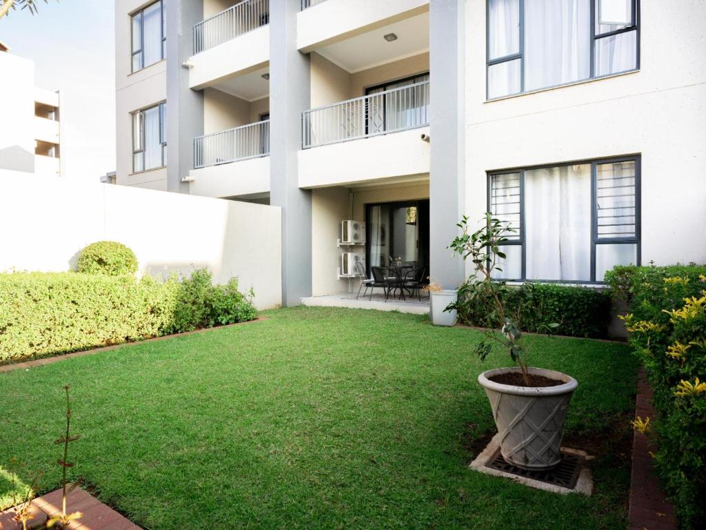 an apartment building with a lawn in front of it at Royal on 81 Ventura in Fourways