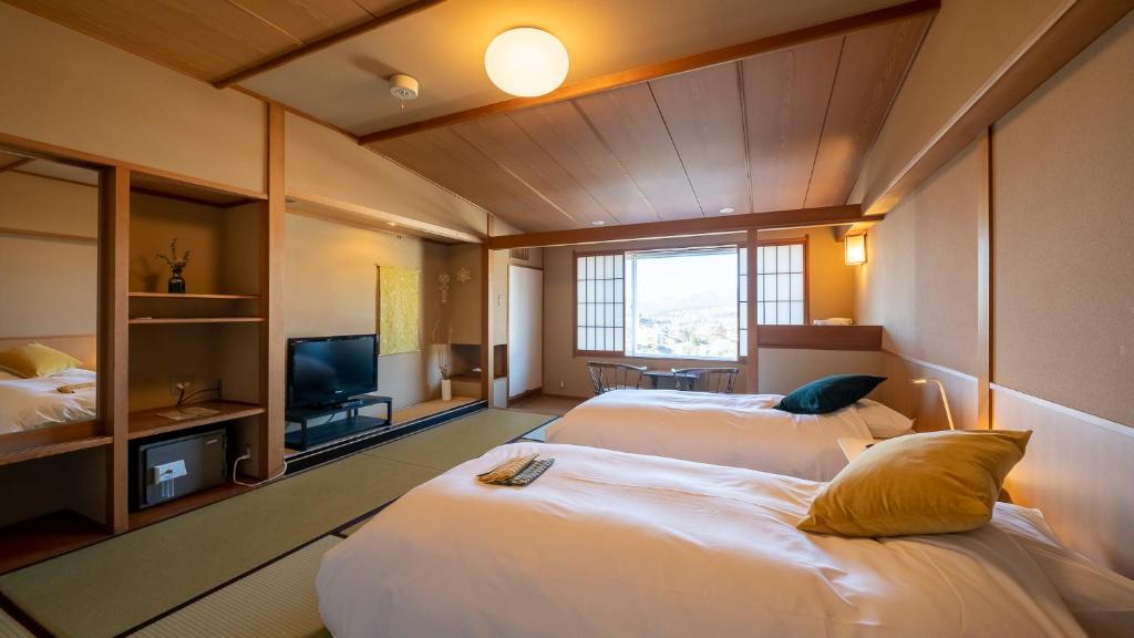 Postel nebo postele na pokoji v ubytování onsen hotel OMOTO