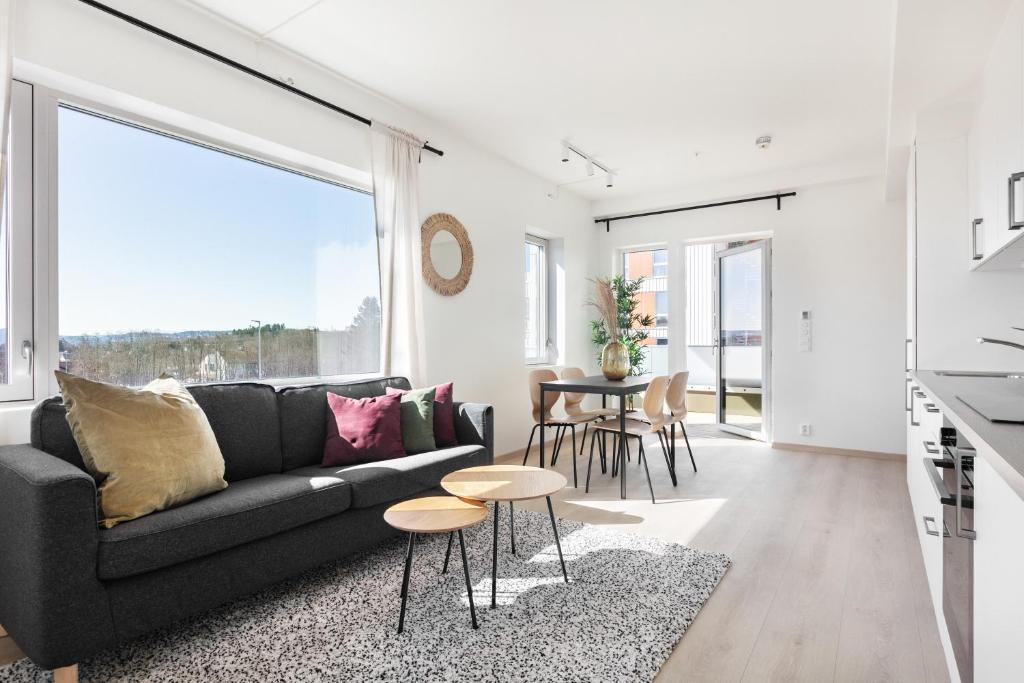 a living room with a black couch and a table at Forenom Serviced Apartments Trondheim in Trondheim