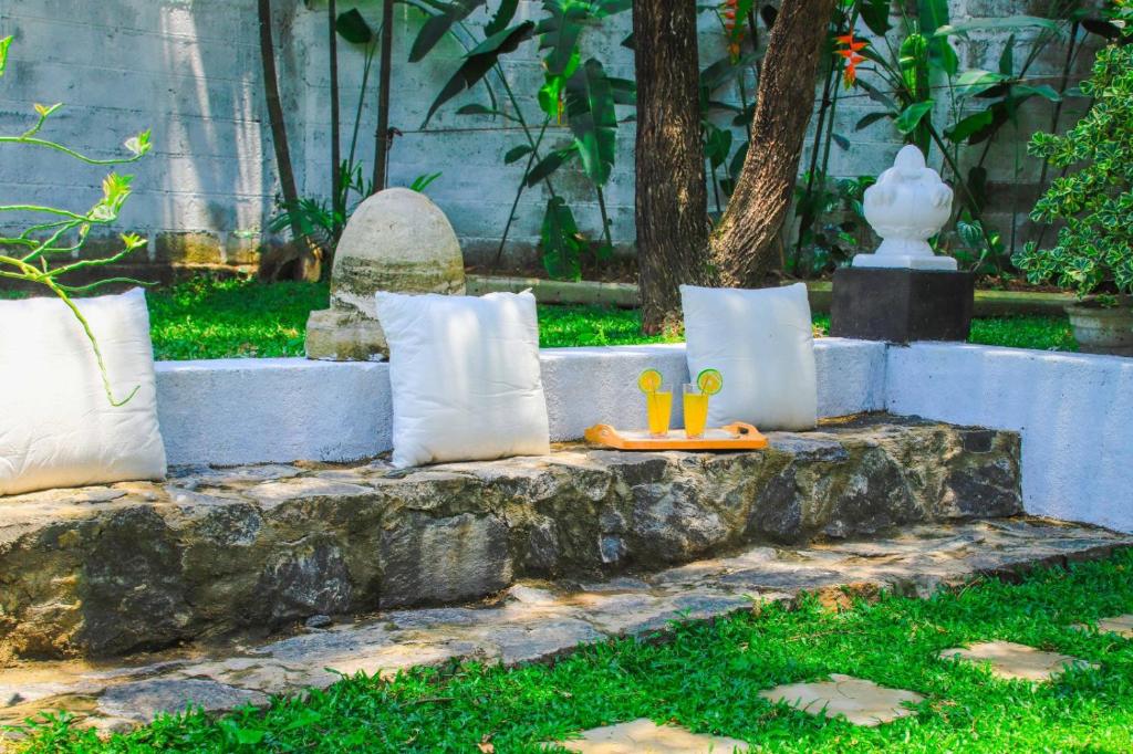 a group of pillows sitting on a stone wall at Tranquill Villa La Dimora in Gampaha