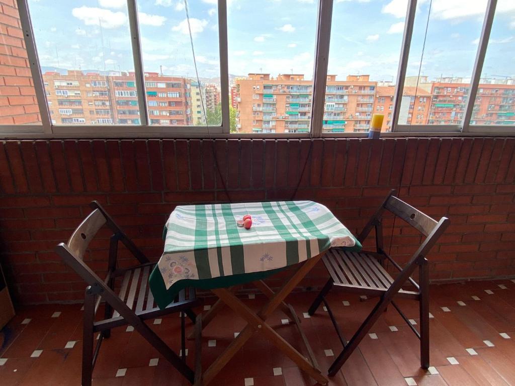 a table and two chairs in a room with windows at Far from the Madding Crowd in Barcelona