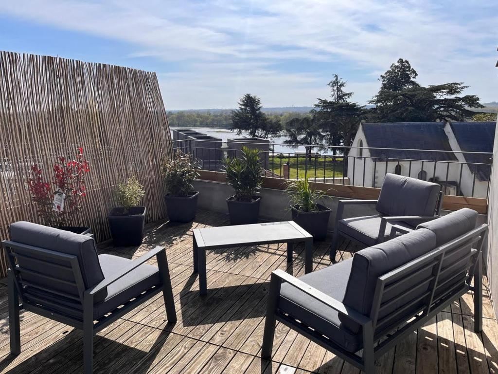 un patio con sillas y mesas en una terraza en petit Gîte T2 des balcons d'Ancenis, en Ancenis