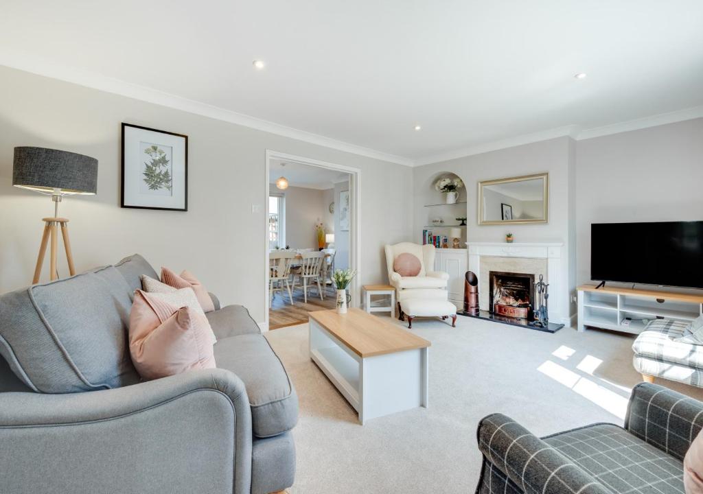 a living room with two couches and a tv at 1 Lux Farm Cottages in Playford