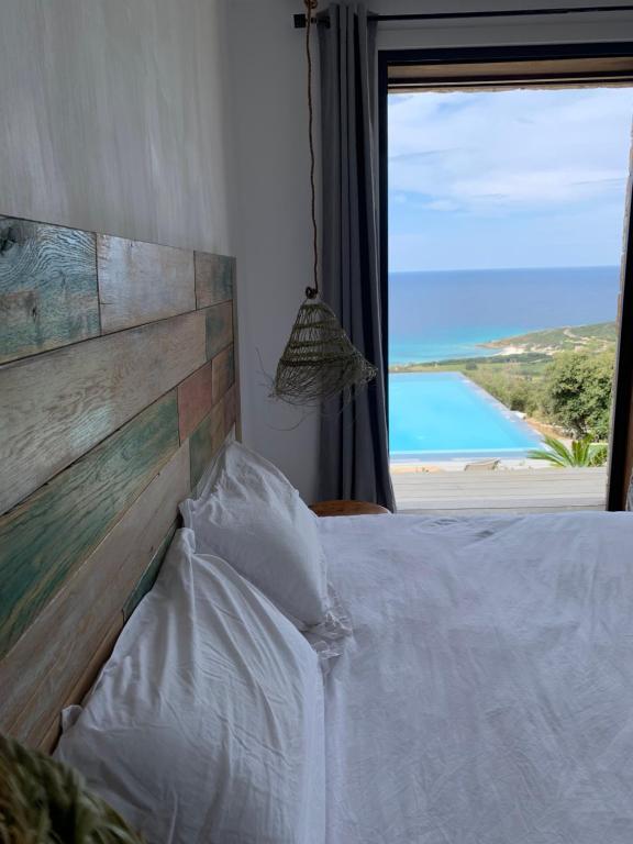 um quarto com uma cama e vista para o oceano em VILLA MACAGNA em Corbara