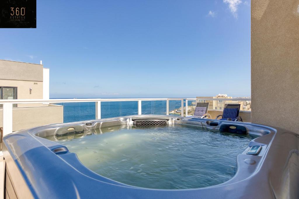 einen Whirlpool auf dem Balkon mit Meerblick in der Unterkunft Luxurious Sea front Penthouse with private HOT TUB by 360 Estates in St Paul's Bay