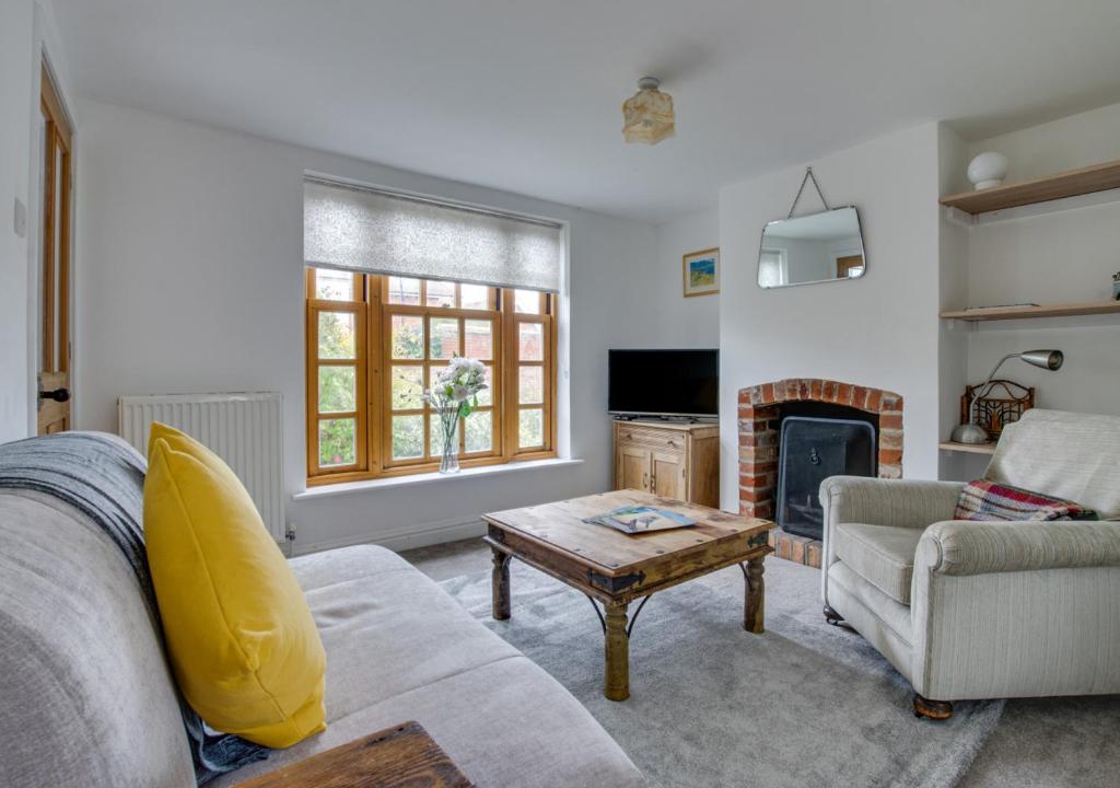 ein Wohnzimmer mit einem Sofa und einem Kamin in der Unterkunft 3 Alde Lane in Aldeburgh