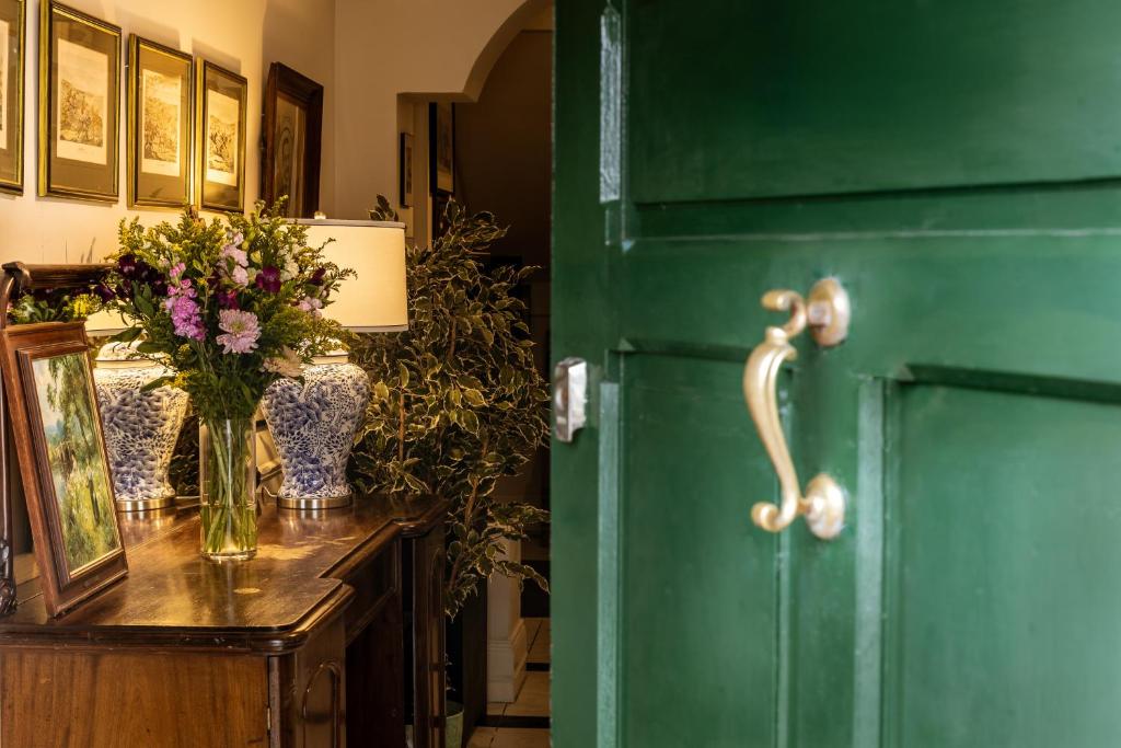 une porte verte avec un vase de fleurs sur un comptoir dans l'établissement An Sugan Guesthouse, à Clonakilty