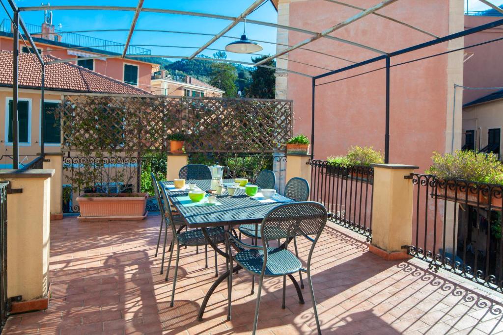 eine Terrasse mit einem Tisch und Stühlen auf dem Balkon in der Unterkunft Chiara House in Levanto