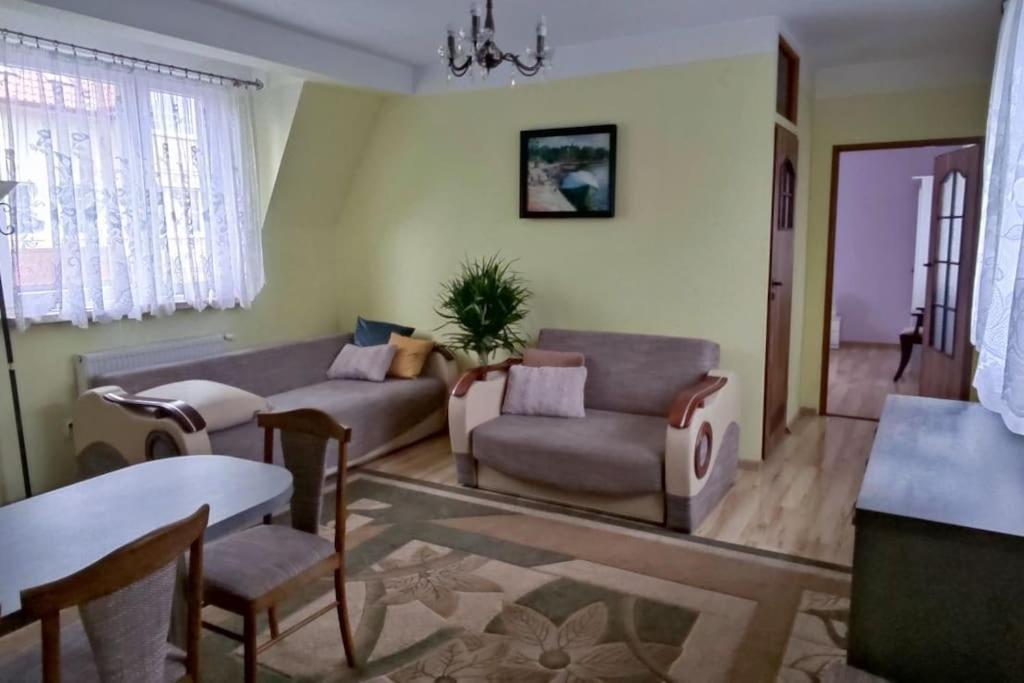 a living room with a couch and a table at Apartament W Podkowie in Mrzeżyno